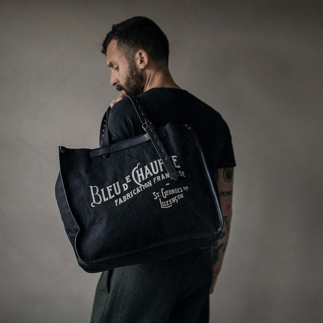 Un homme porte dans son dos le cabas en toile "Bazar"