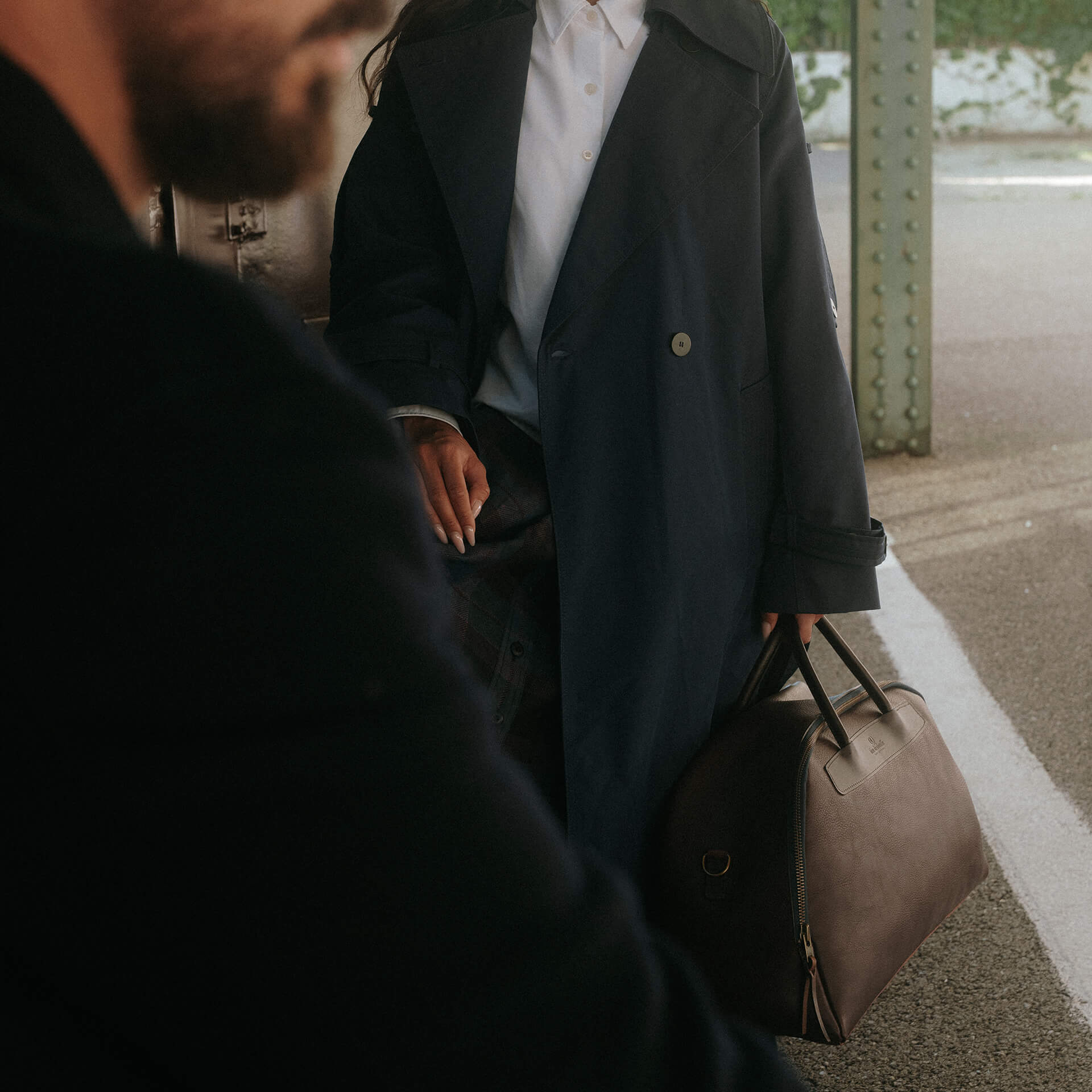 Bolso de viaje de piel para mujer, foto de ambiente en una estación de tren