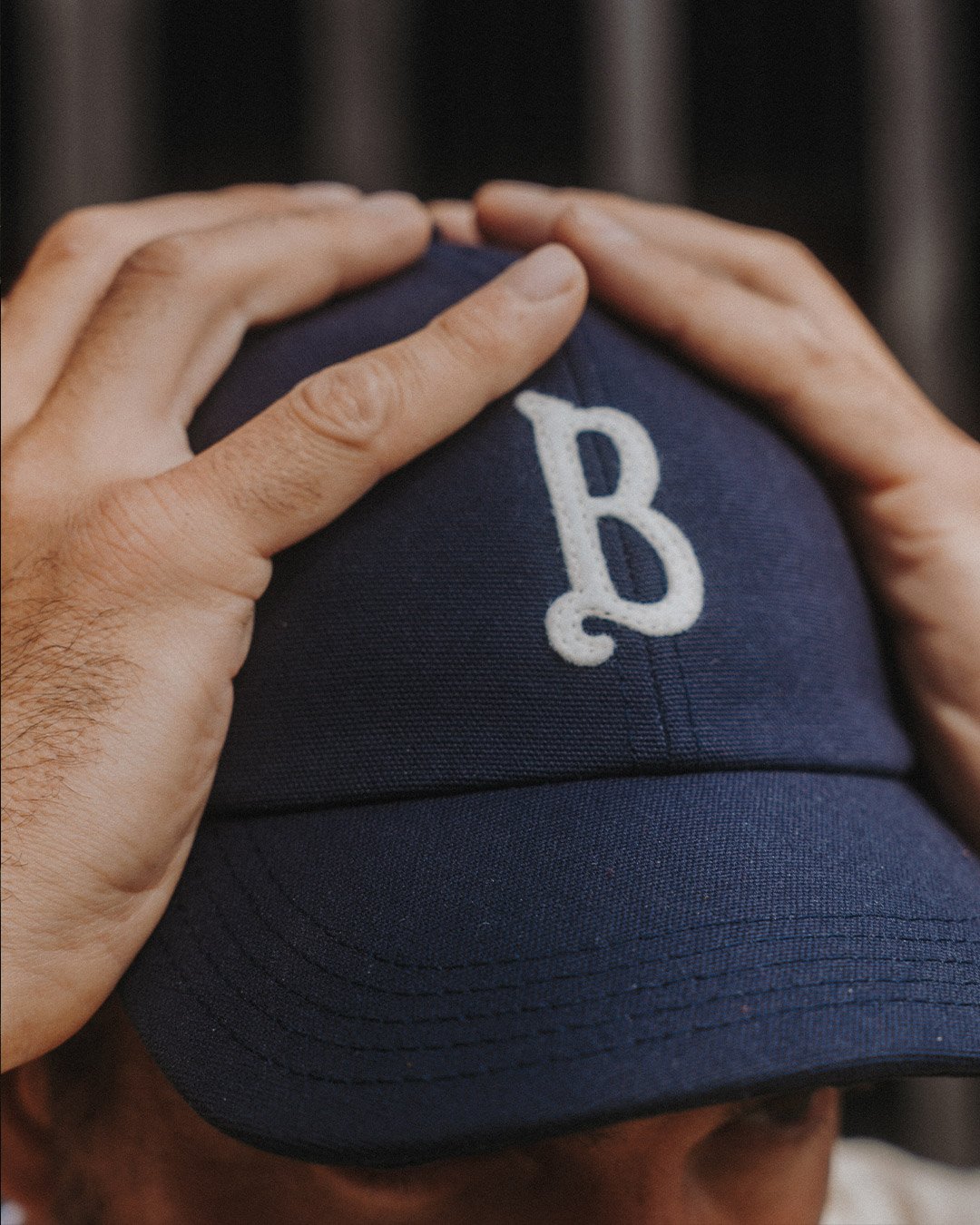 Un homme tient sa casquette bleu sur sa tete