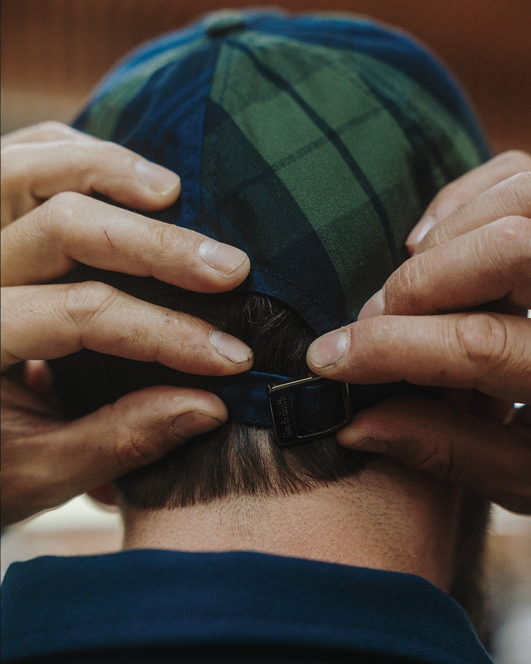 A man adjusts his Gaspard cap using the tightening buckle