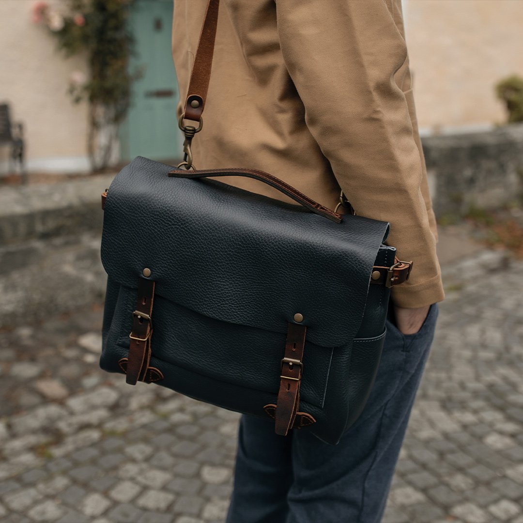 Gros plan sur le sac en cuir bleu "Eclair M" porté à l'épaule