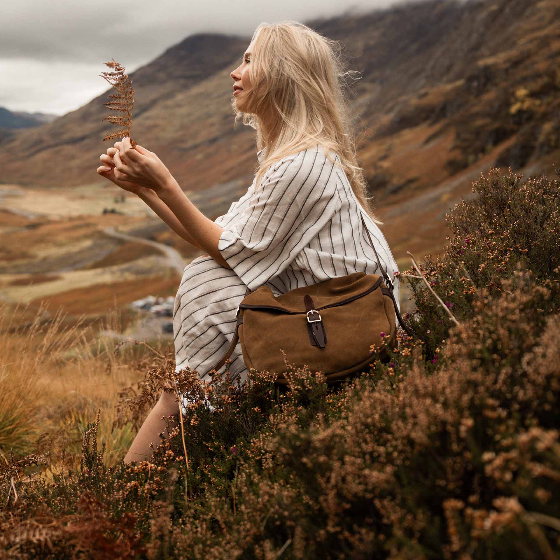 Une femme porte en bandouliere un sac musette