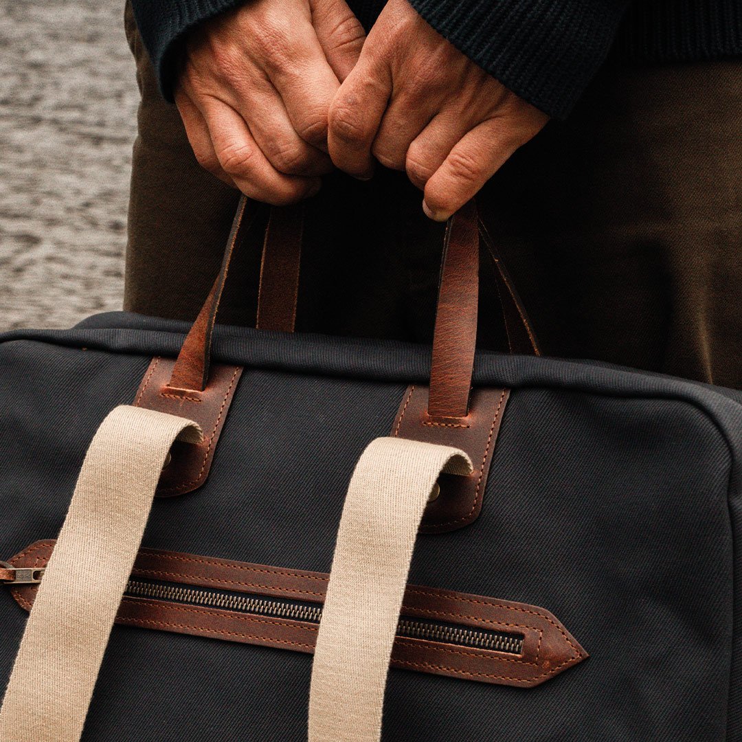 Close-up of the leather handles and cotton strap on the Missak travel bag