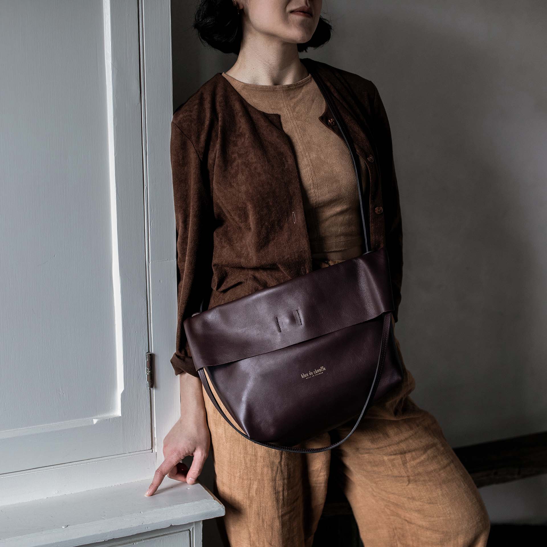 Une femme porte en bandouliere le sac Mission