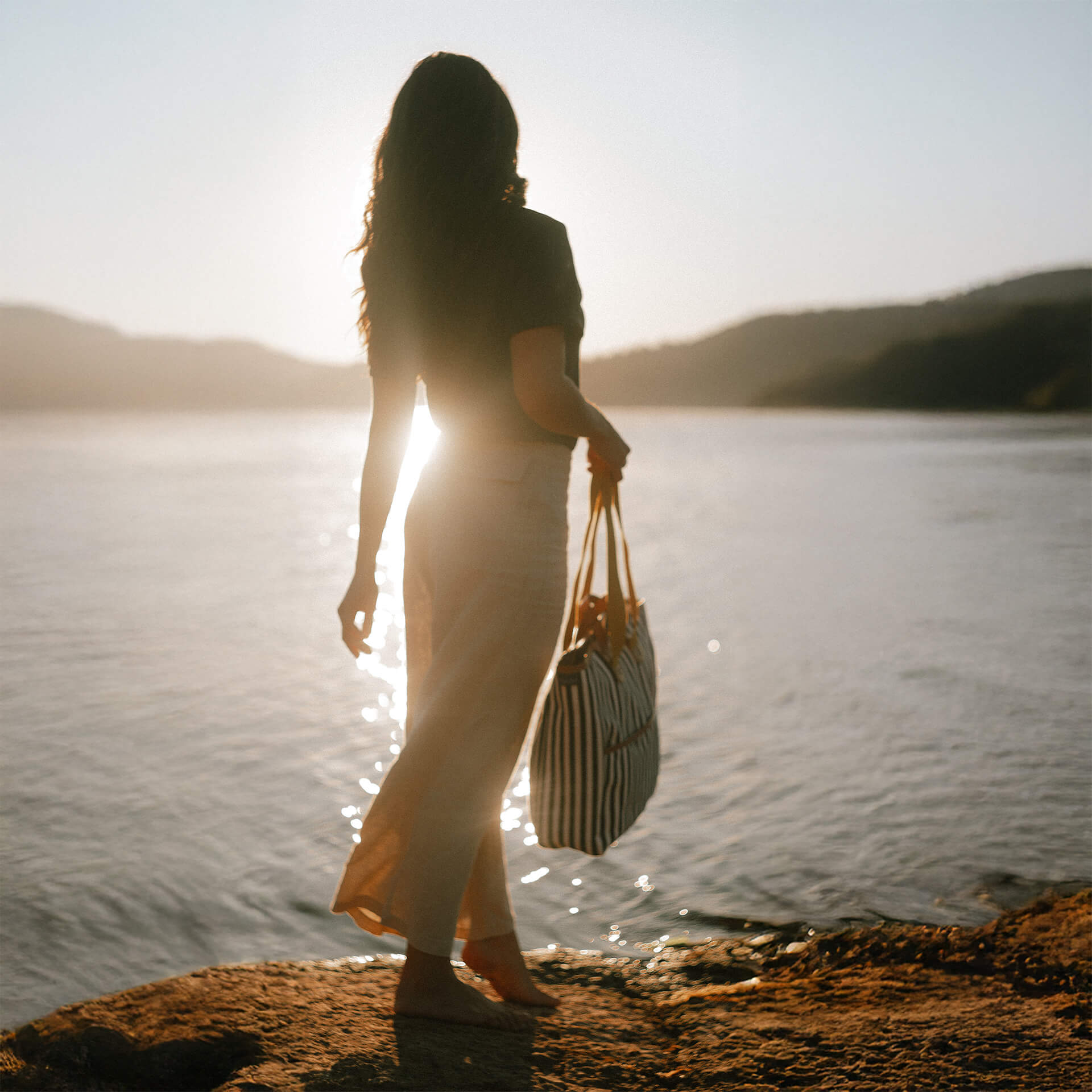 Canvas tote for women worn by a women in front of a lake