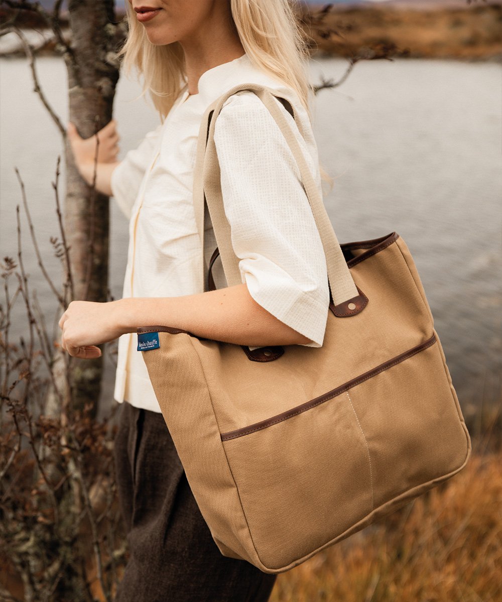 A woman slings her canvas shopping bag over her shoulder