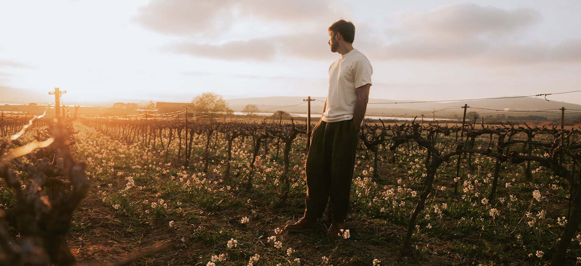 un homme regarde un couché de soleil, il porte le t-shirt Bleu de Chauffe