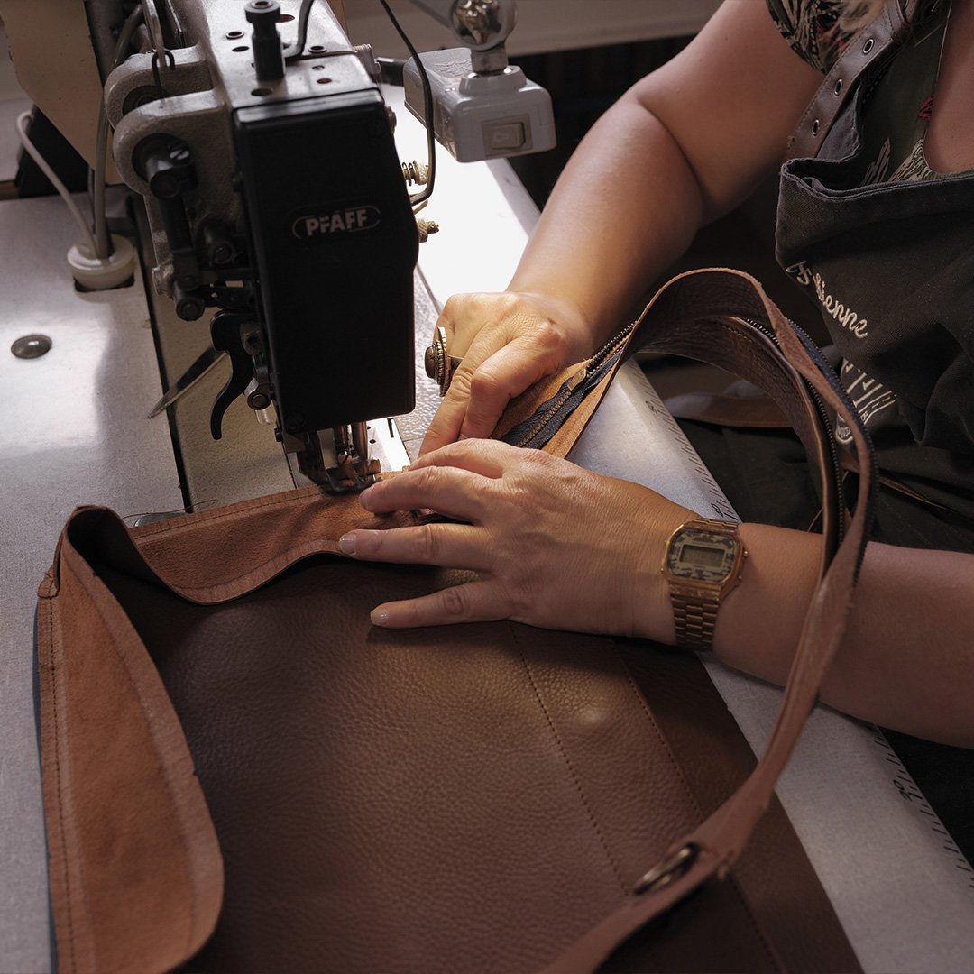 Un maroquinier de Bleu de Chauffe en train de monter un sac