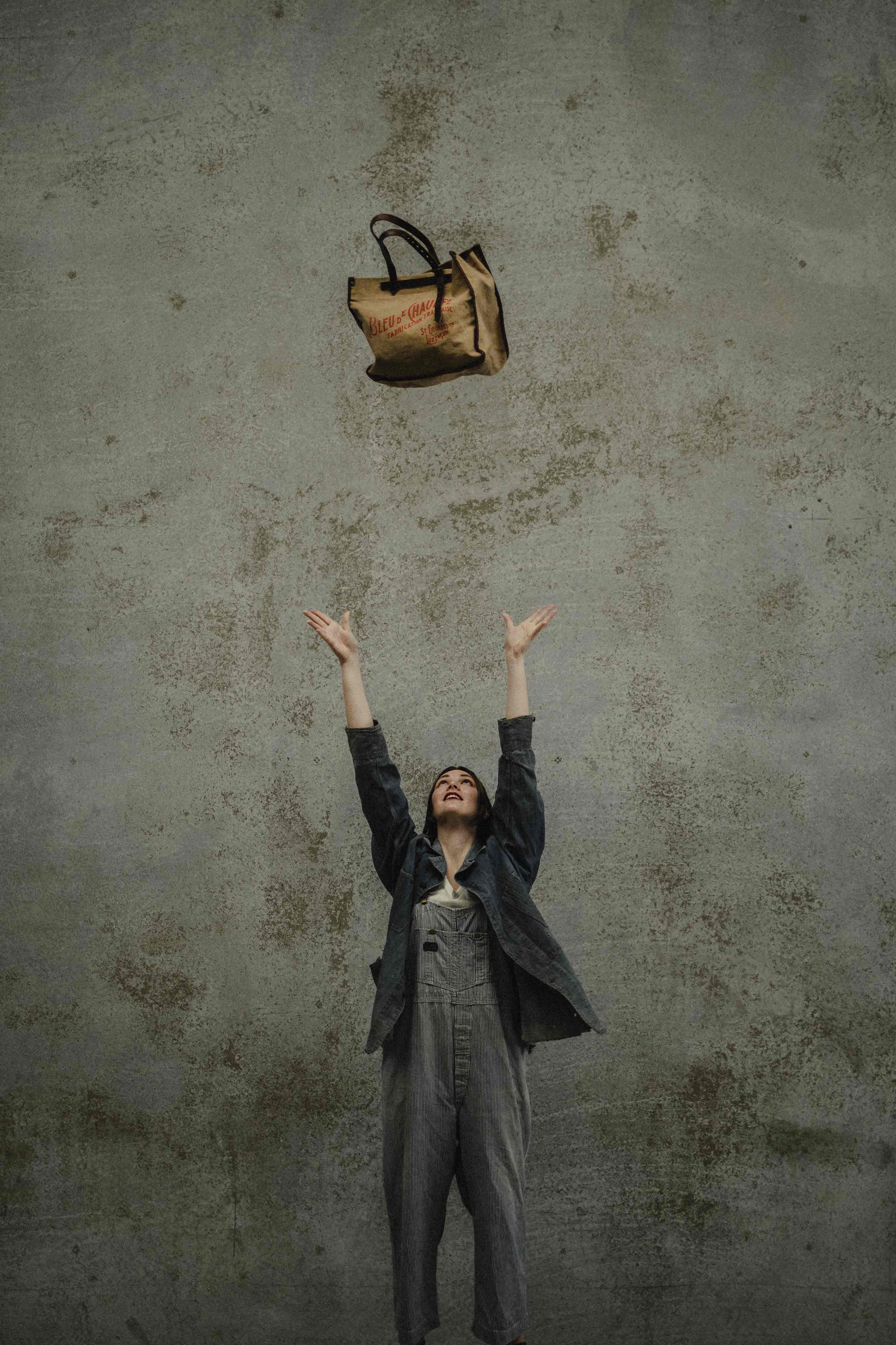 A woman throws a French-made shopping bag over her head