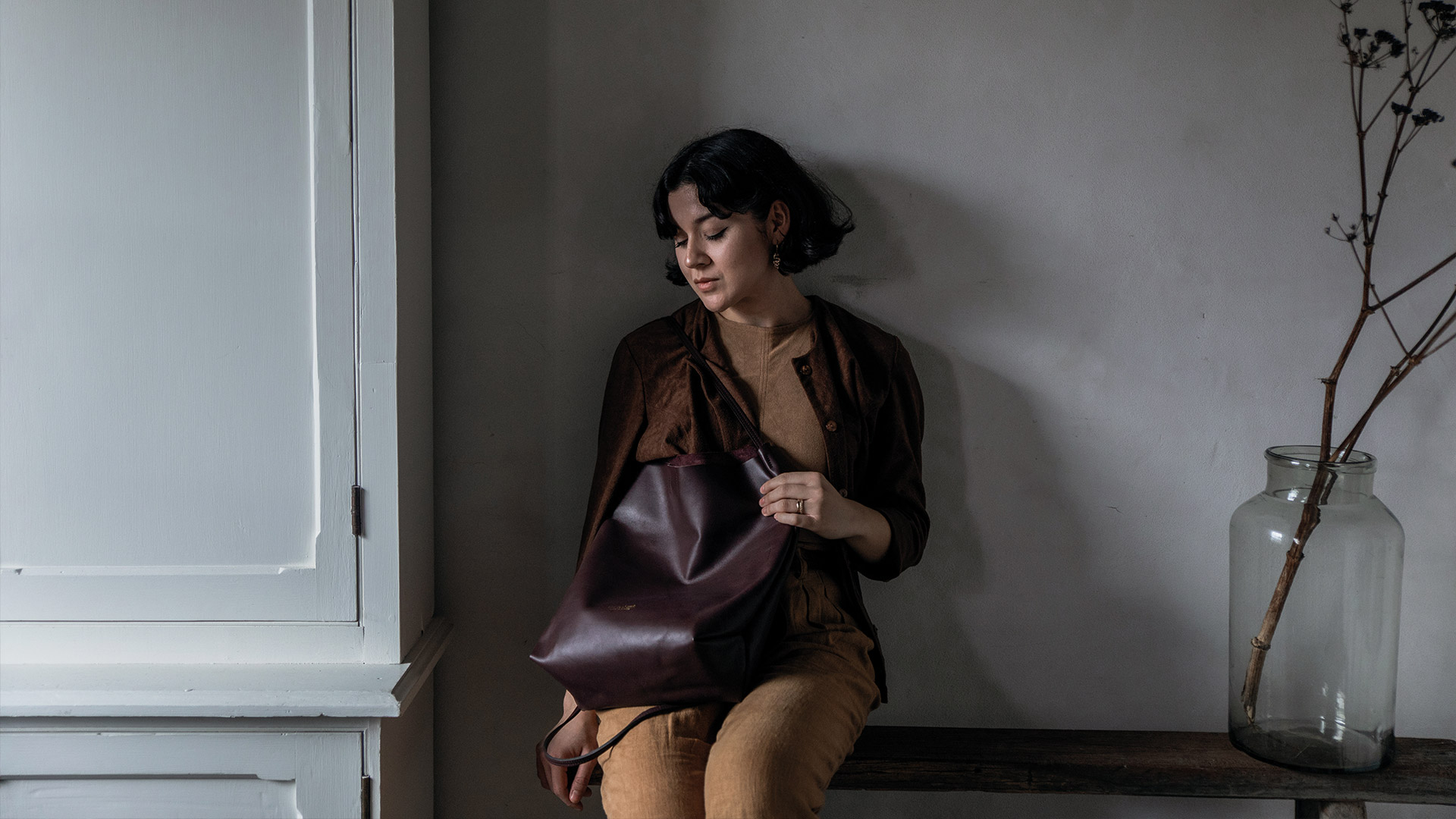 A woman carries the Mission leather bag