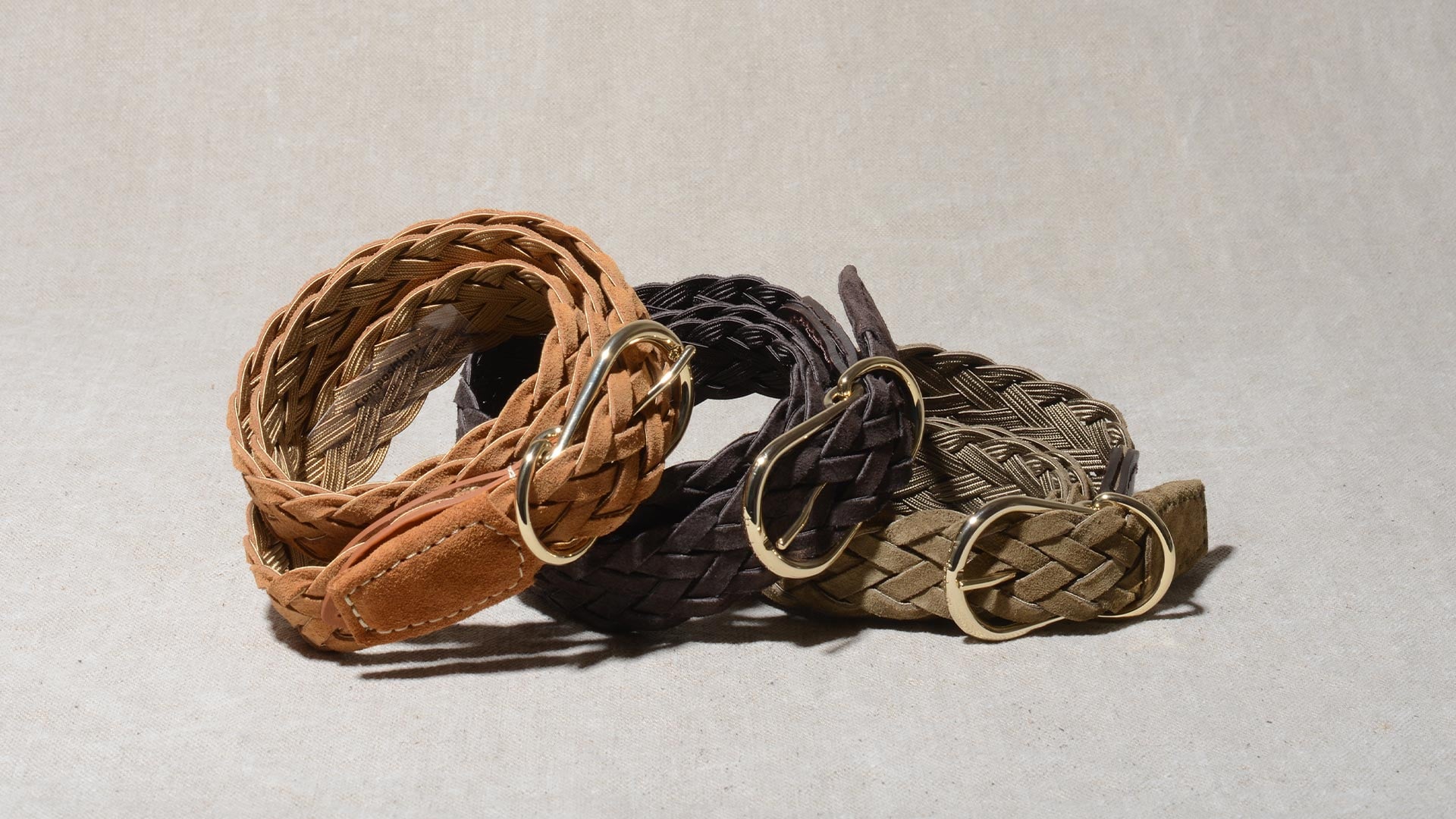 A man carries a leather bag and a Bleu de Chauffe belt under his arm