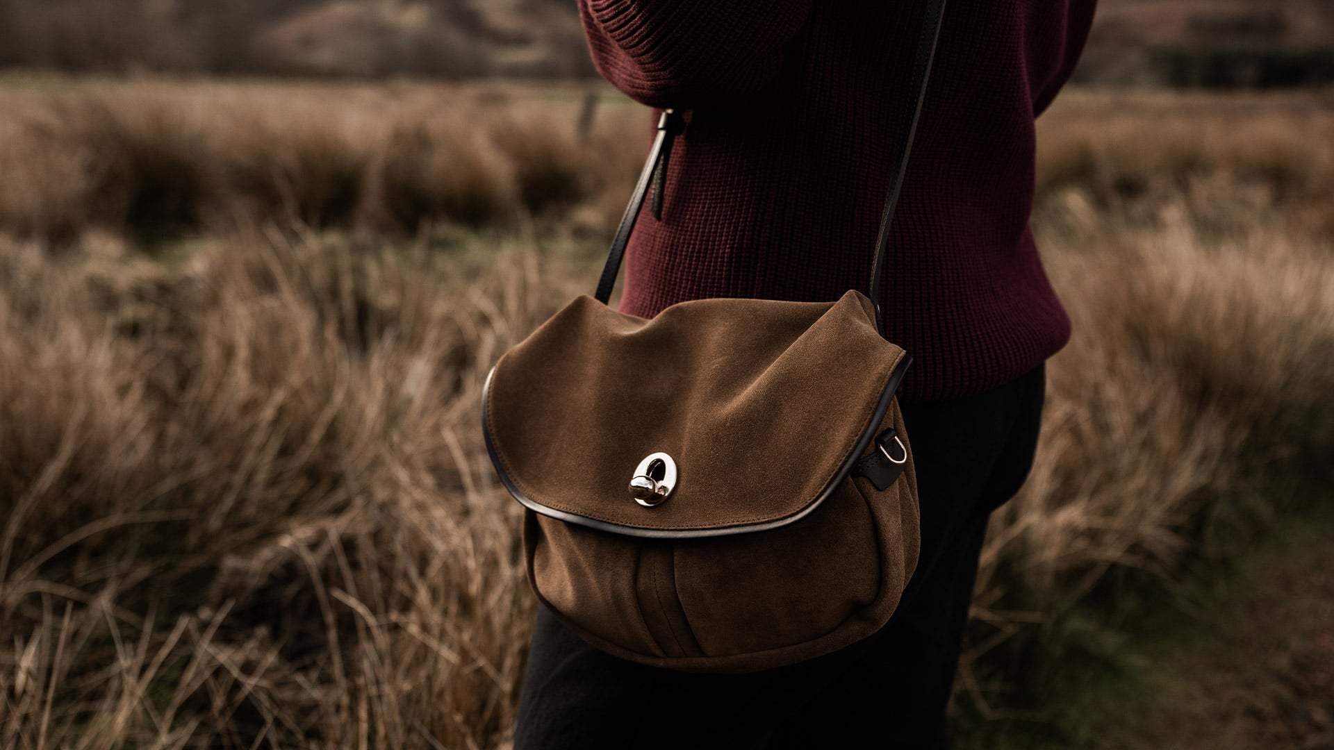 A woman carries the Mission leather bag