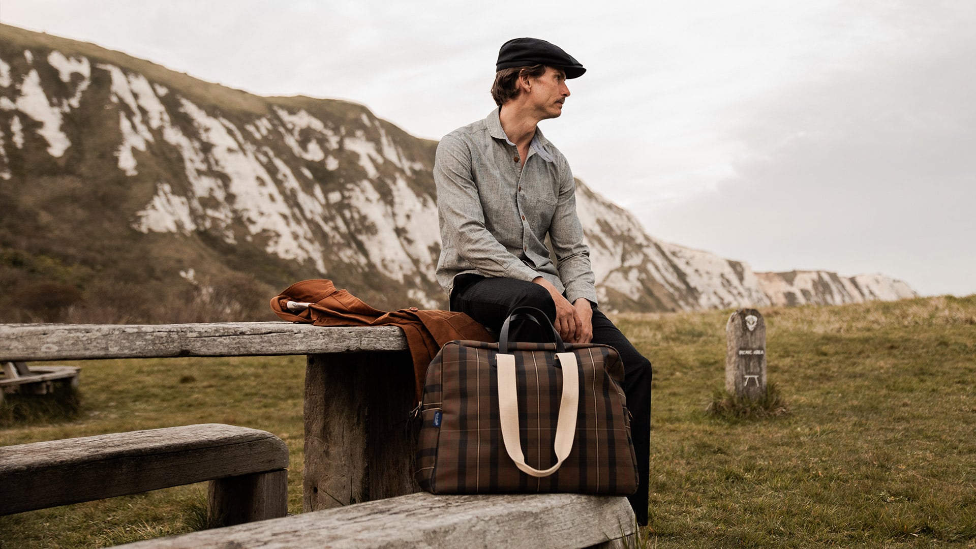 Une femme porte à l'épaule le sac de voyage en cuir Hobo