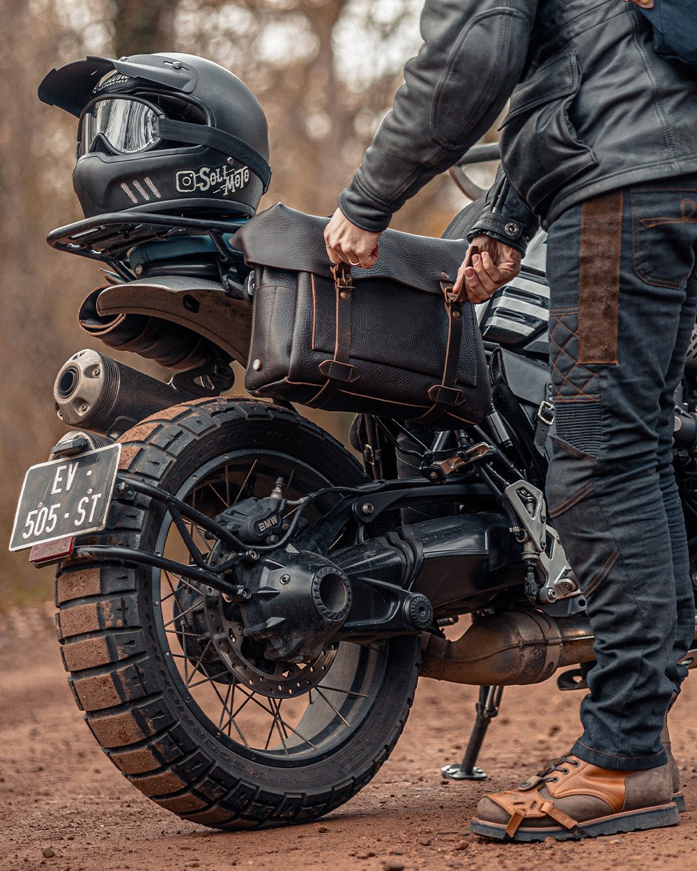 Men's leather bag attached to the back of a motorcycle