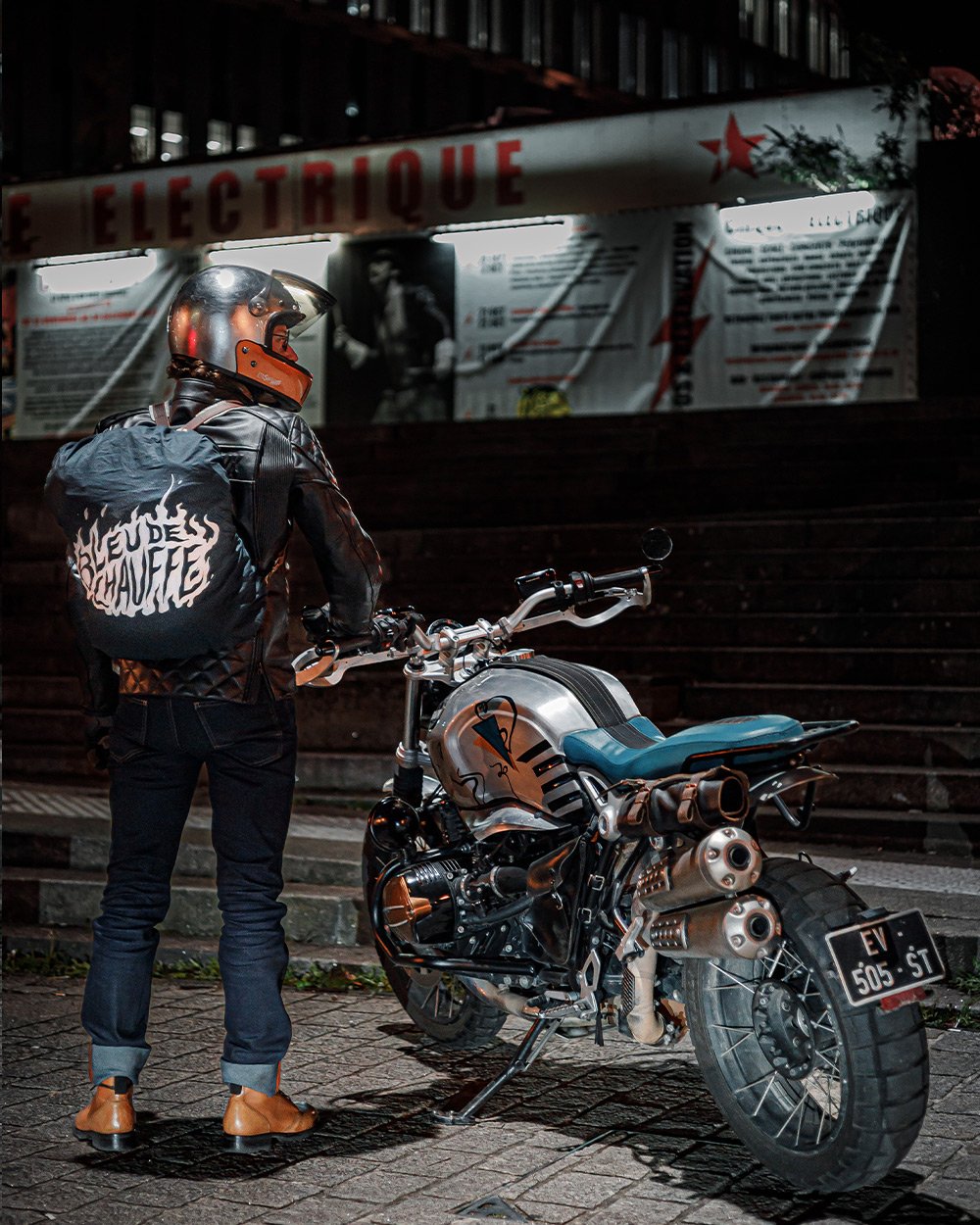 A man from behind with his motorcycle in town