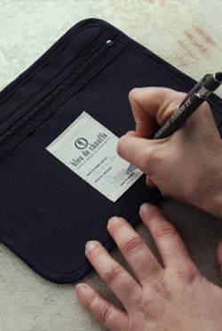 un artisan signe une poche intérieure zippé