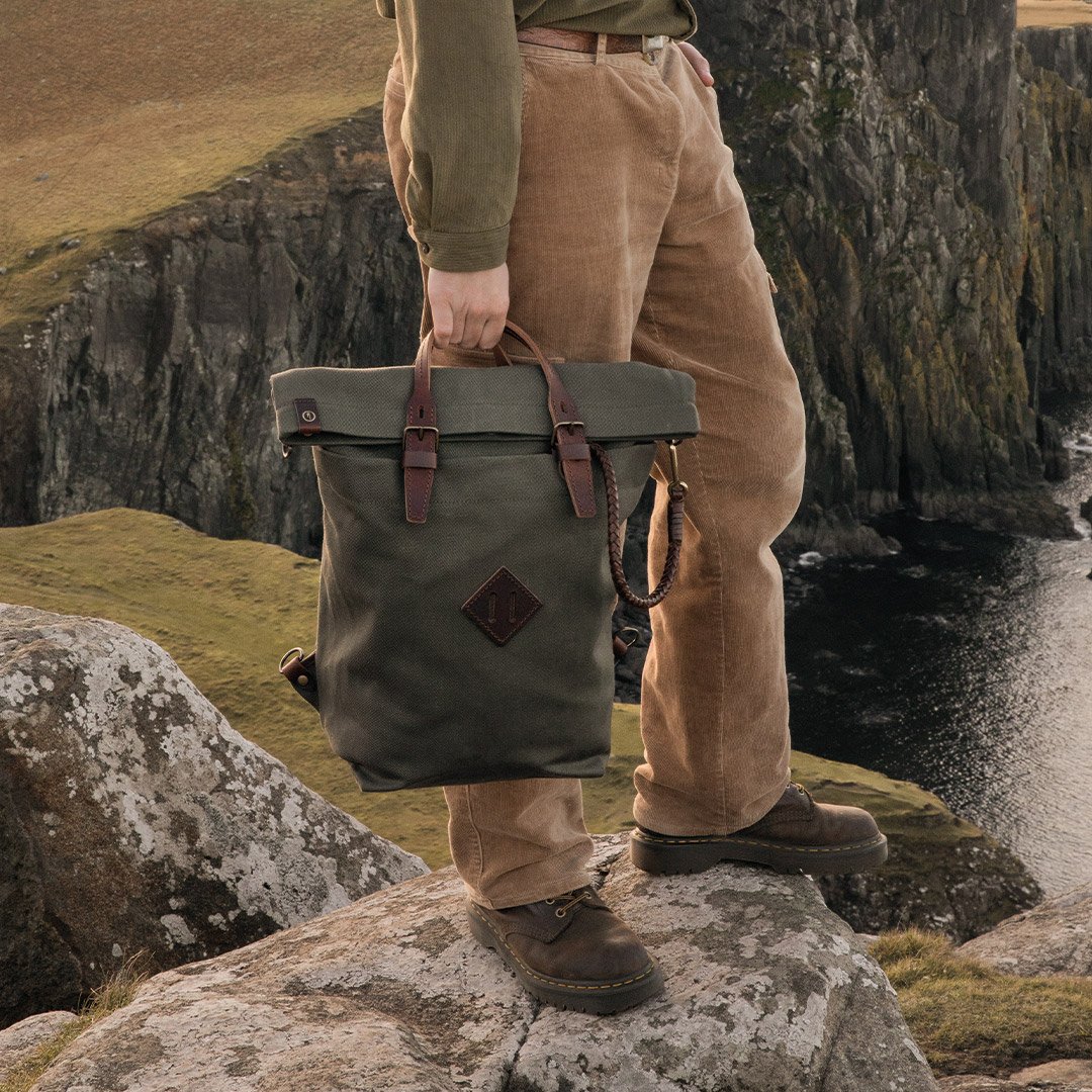 One person carries the Woody canvas backpack by the handle