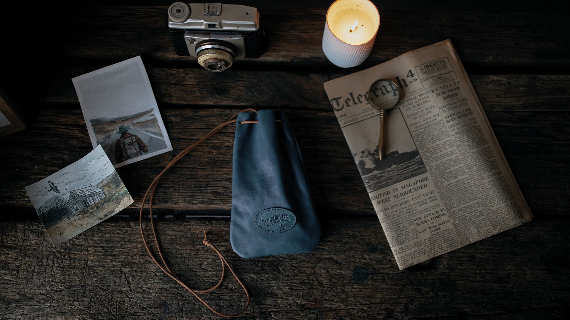 A leather purse sits on a wooden table.