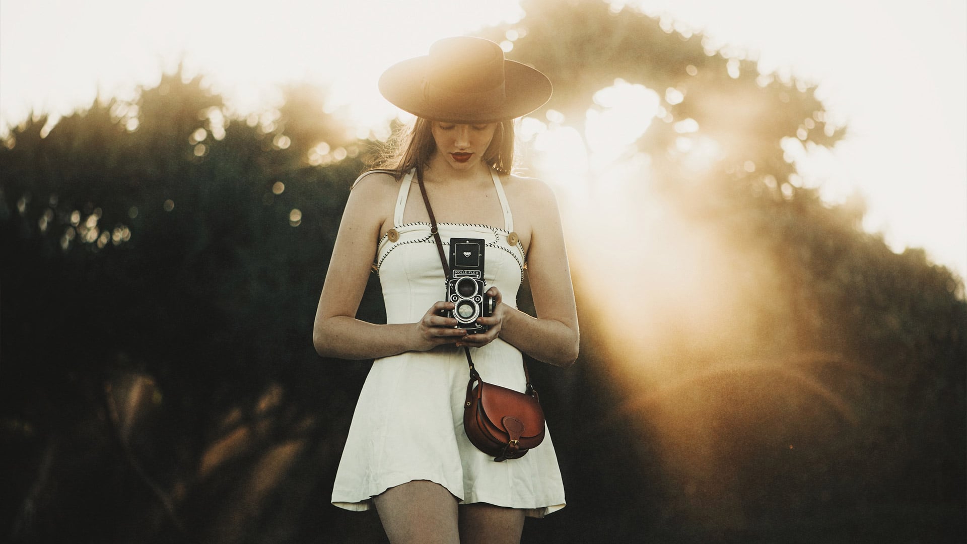 Une femme prends des photos avec un ancien appreil photo dans une ambiance ethereal