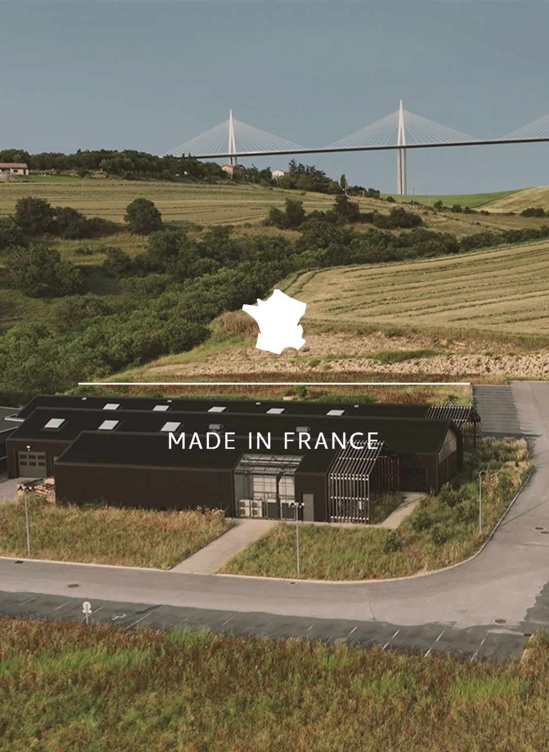 Vue a&eacute;rienne de l'atelier de Bleu de Chauffe, avec le viaduc de Millau en arriere plan. 