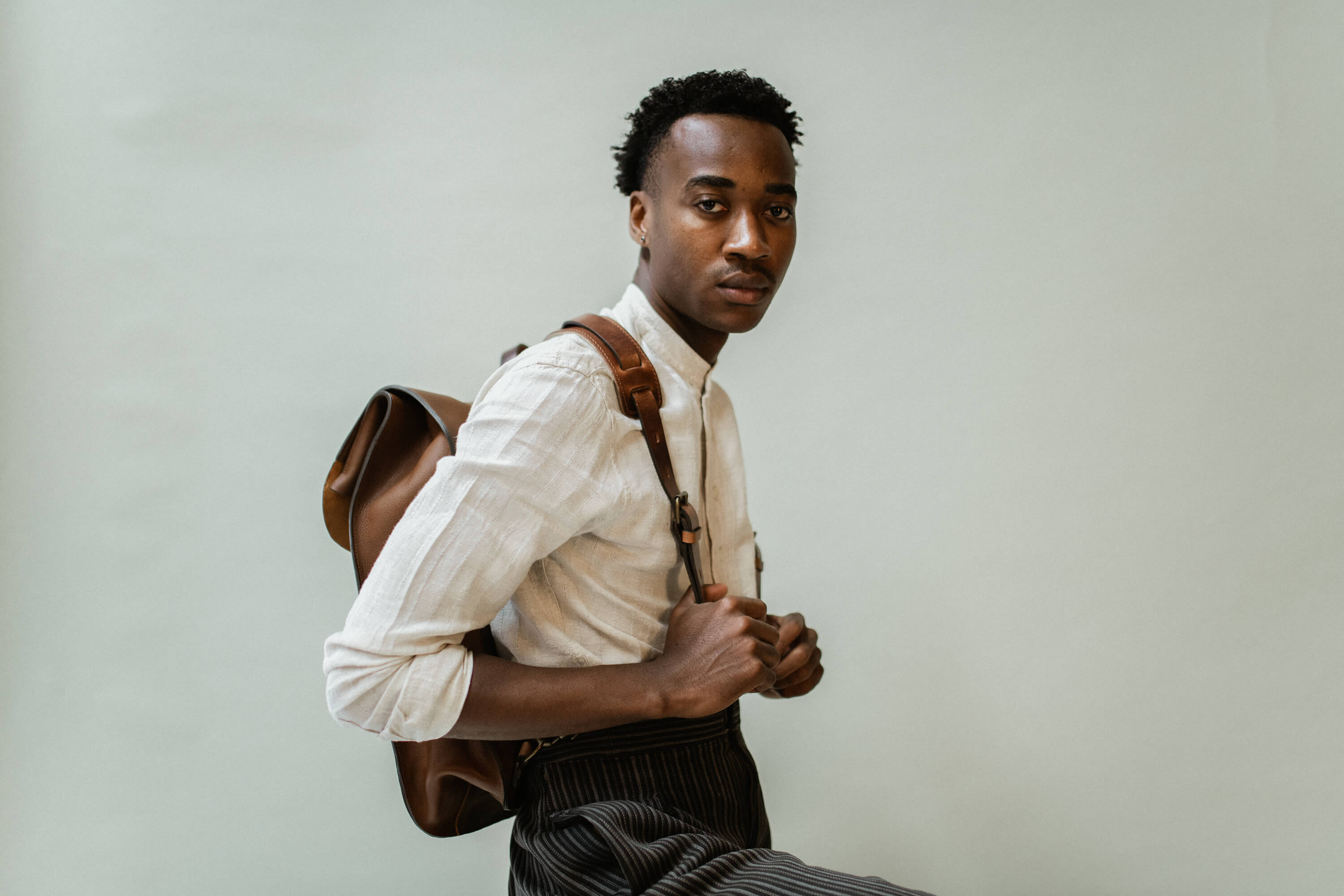 A man carrying a leather backpack