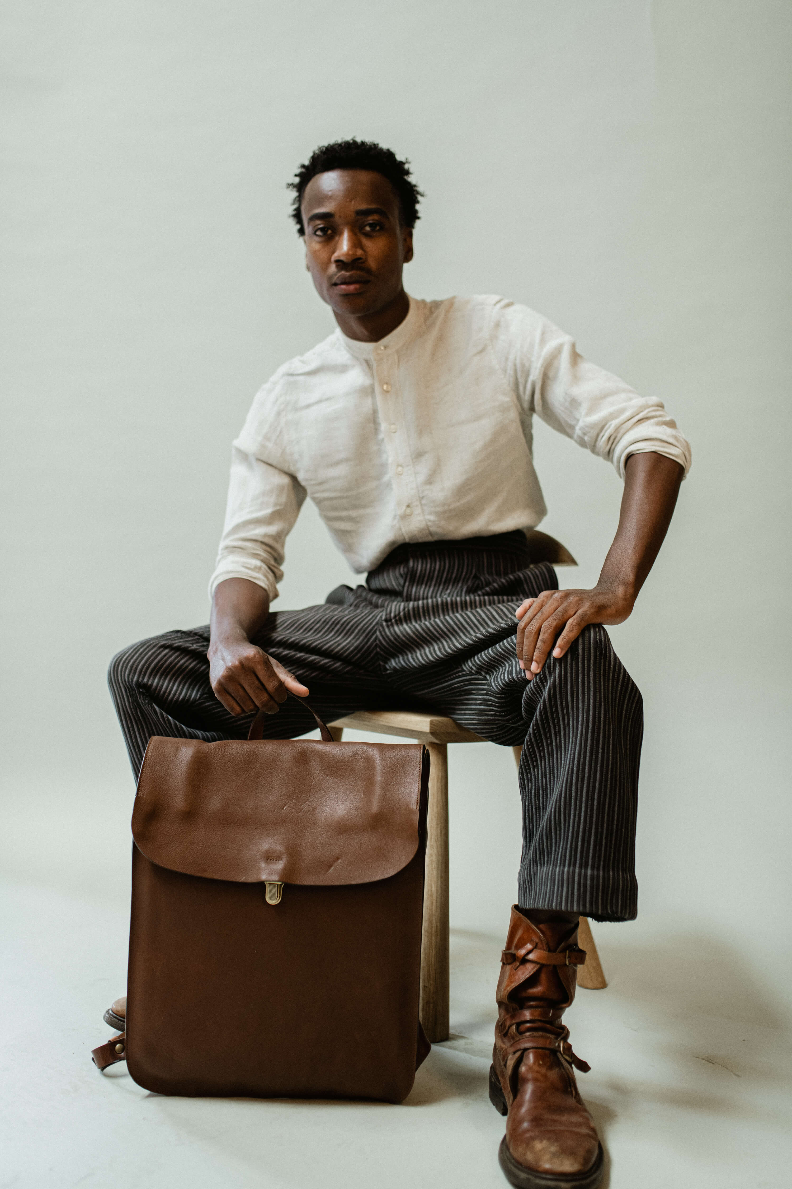 Un jeune homme pose devant son sac a dos en cuir Arlo