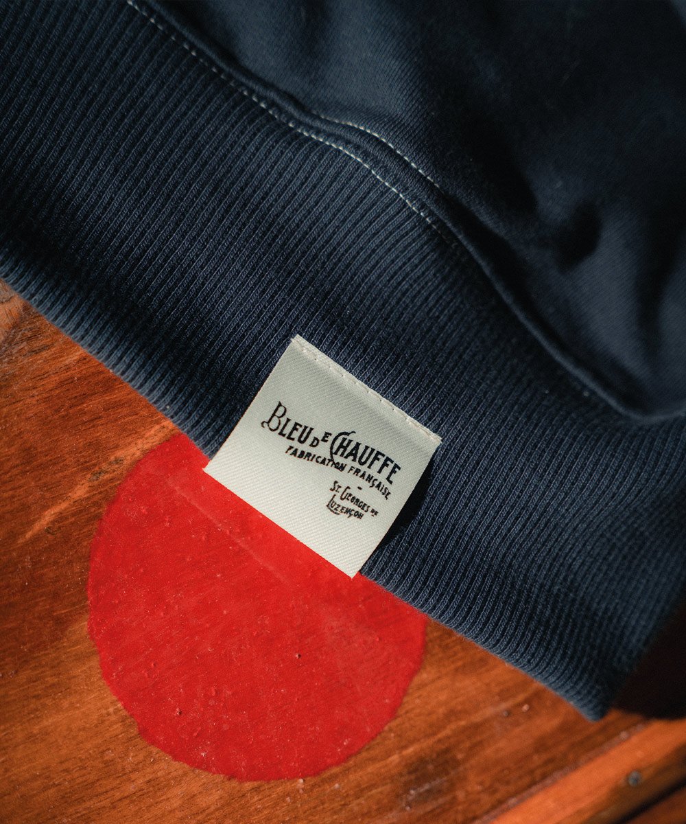 Detailansicht des Herrenpullovers mit dem Etikett „Bleu de Chauffe St-Georges-de-Luzencon”