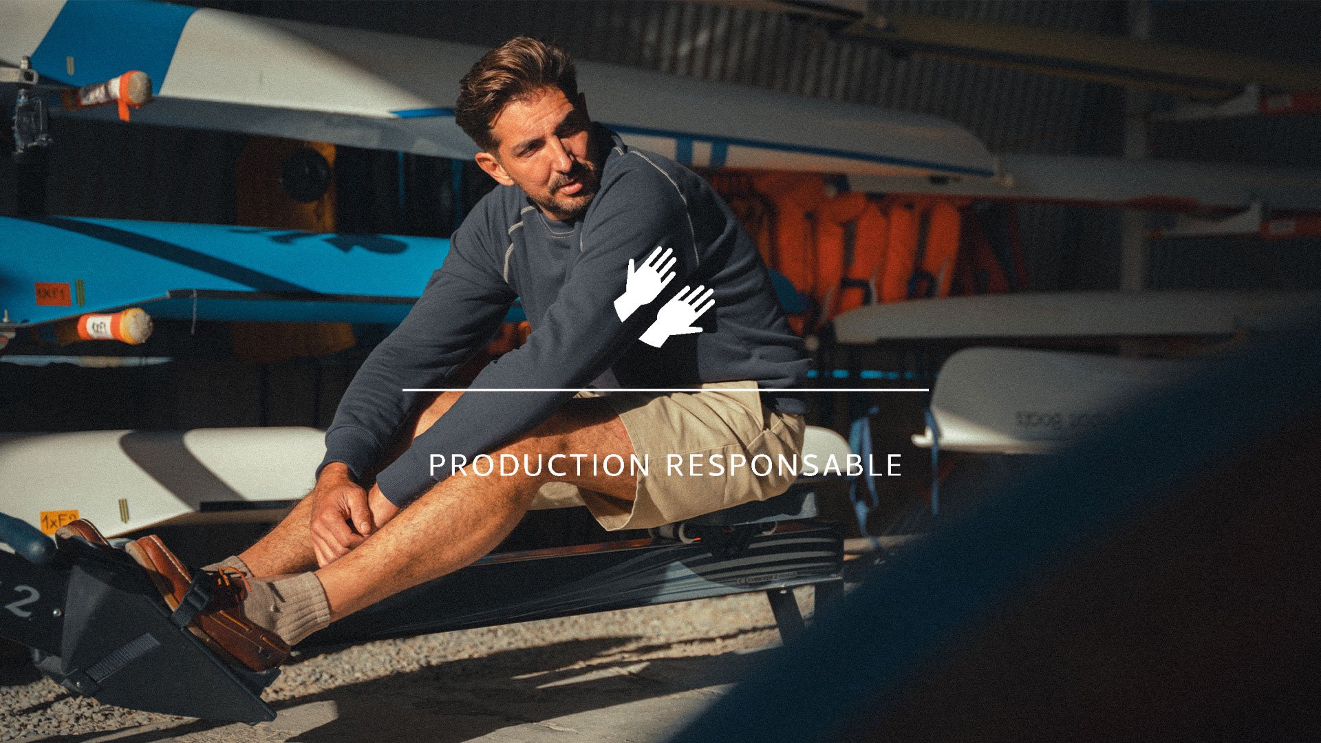 Un homme assis porte le sweat made in france de Bleu de Chauffe