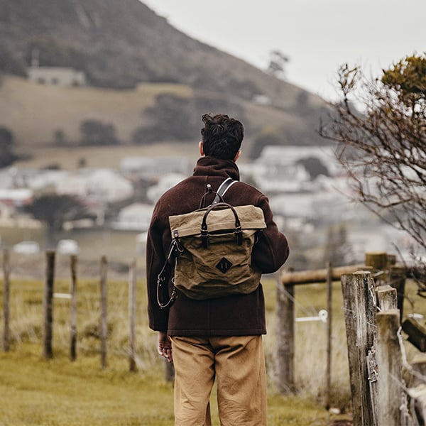 A man carries the woody backpack and looks at the horizon