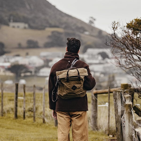 Un homme porte le sac a dos woody et regarde l'horizon 