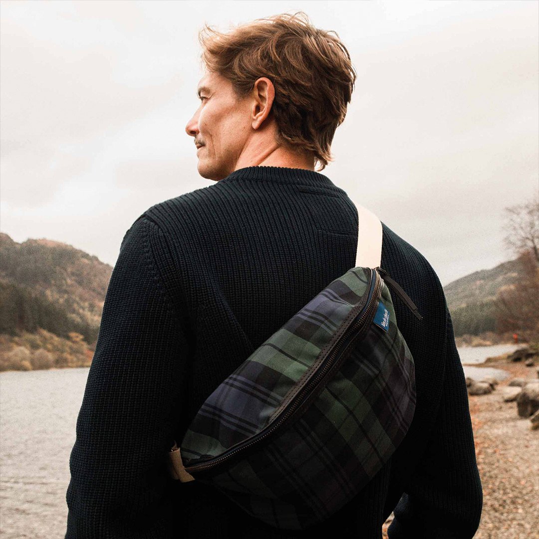 A man with his back to the tartan-colored xl fanny pack
